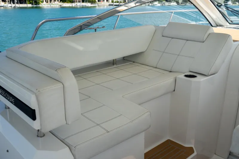  Yacht Photos Pics 2018 Cruisers Yachts 390 Express Coupe interior seating with white upholstery and cup holder.
