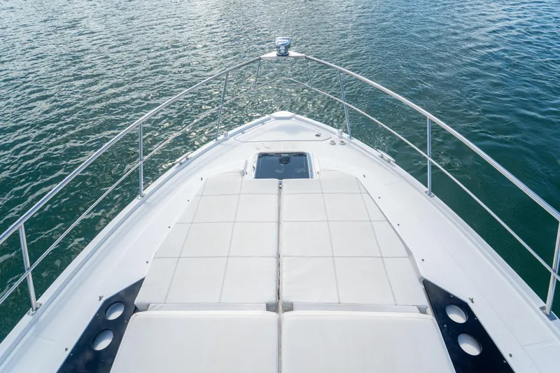  Yacht Photos Pics 2018 Cruisers Yachts 390 Express Coupe bow view on water, featuring sunpad and railing.