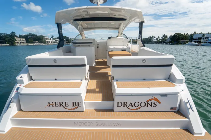  Yacht Photos Pics 2018 Cruisers Yachts 390 Express Coupe on water, rear view, "Here Be Dragons" text.