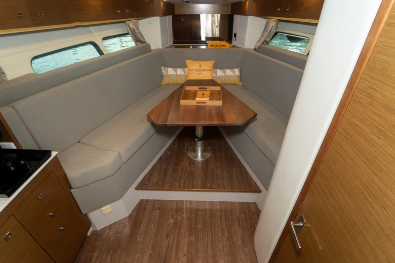  Yacht Photos Pics 2018 Cruisers Yachts 390 Express Coupe interior with elegant dining area and wooden finishes.