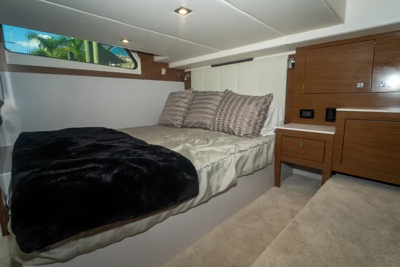  Yacht Photos Pics Luxurious cabin interior of 2018 Cruisers Yachts 390 Express Coupe with cozy bed and wooden cabinetry.