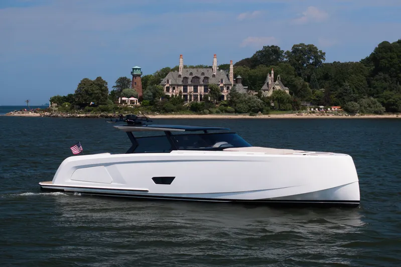 Take It Easy V Yacht Photos Pics 2022 Vanquish VQ58 yacht cruising near a historic mansion on a sunny day.