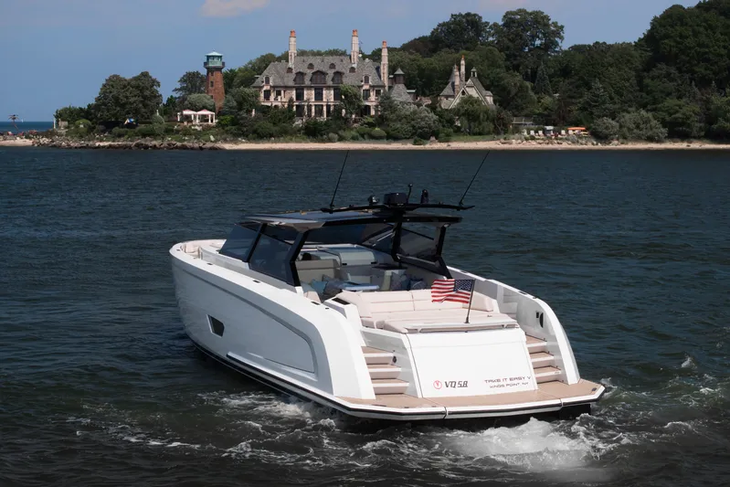 Take It Easy V Yacht Photos Pics Vanquish VQ58 yacht cruising near a scenic shoreline with a historic mansion, 2022 model.