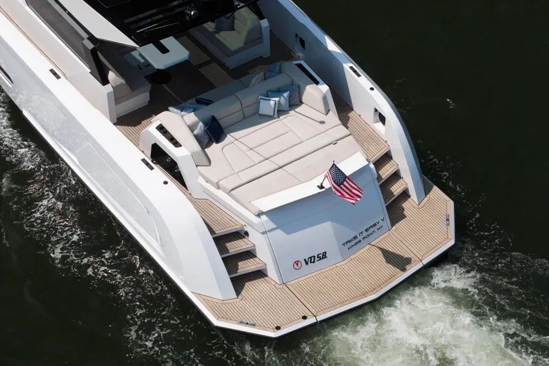 Take It Easy V Yacht Photos Pics Luxury Vanquish VQ58 yacht, 2022 model, cruising with elegant deck seating and American flag.