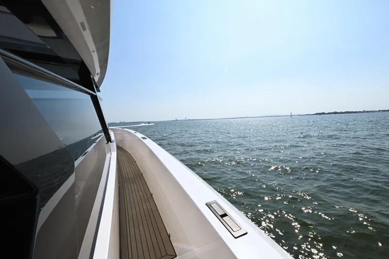 Take It Easy V Yacht Photos Pics 2022 Vanquish VQ58 yacht cruising on open water under clear blue sky.
