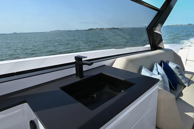 Take It Easy V Yacht Photos Pics Luxury Vanquish VQ58 yacht interior with sleek sink and comfortable seating, 2022 model.