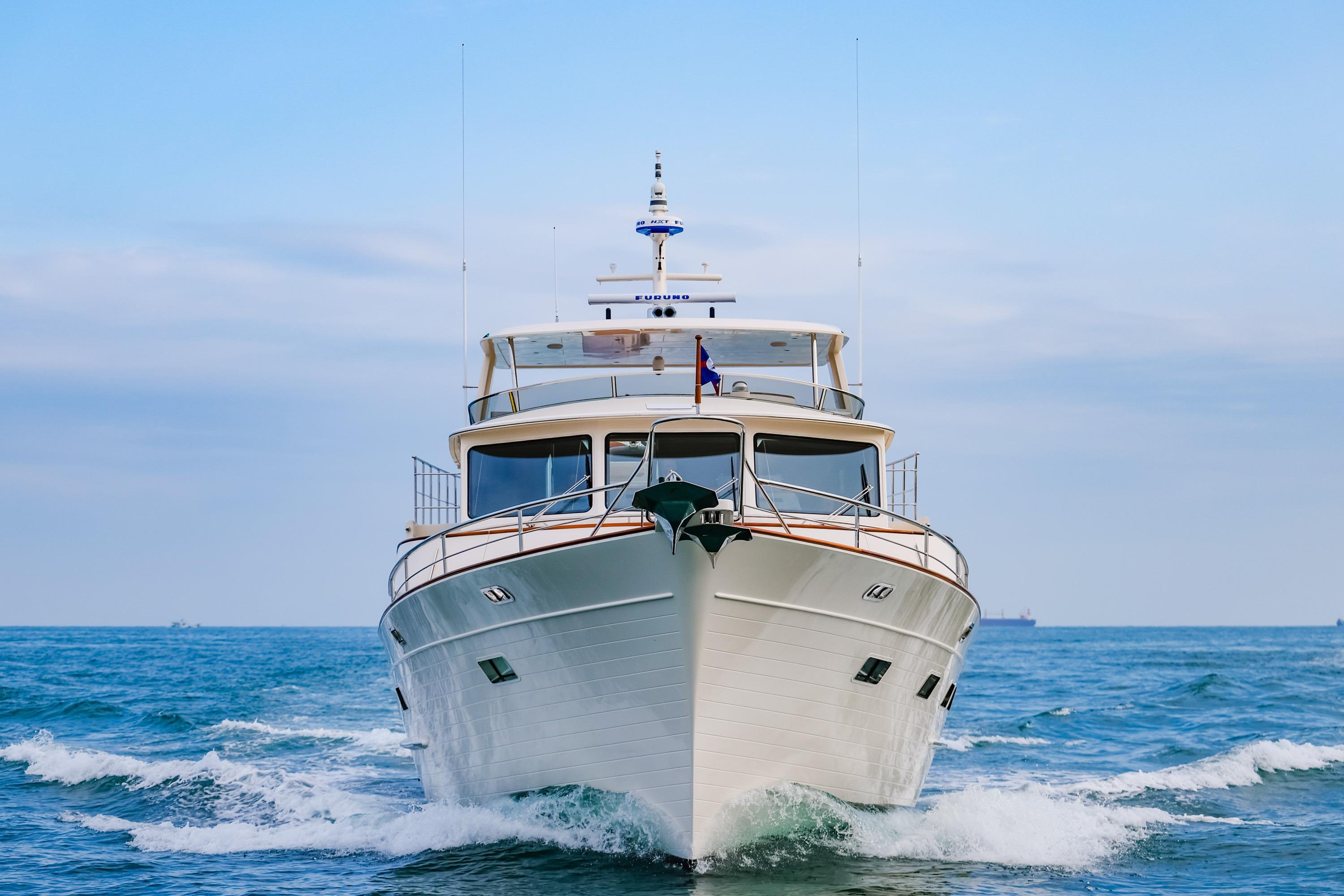 Front view of 2027 Fleming 85 Pilothouse yacht cruising on open sea.