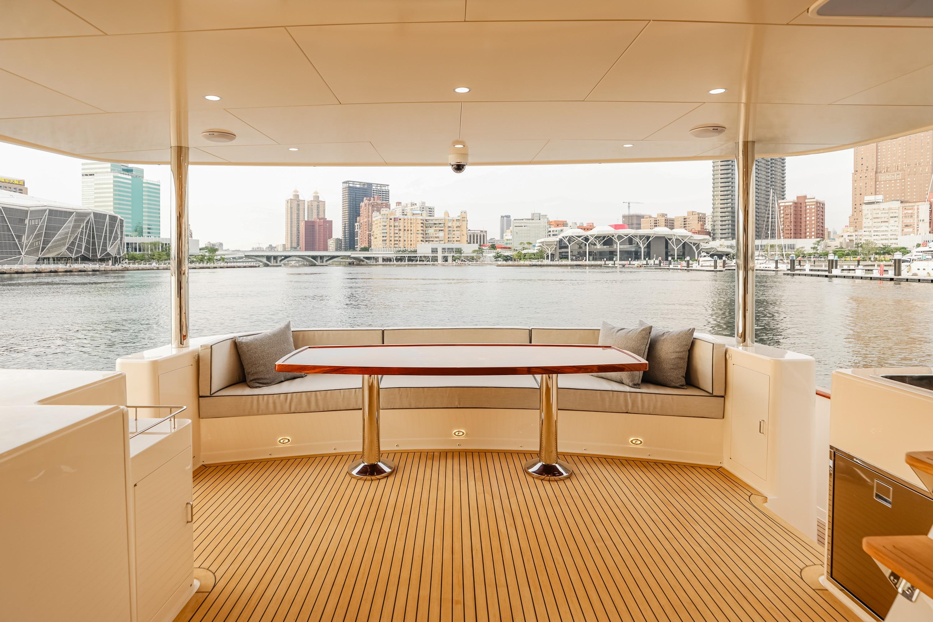 Luxurious 2027 Fleming 85 Pilothouse yacht deck with waterfront city view.