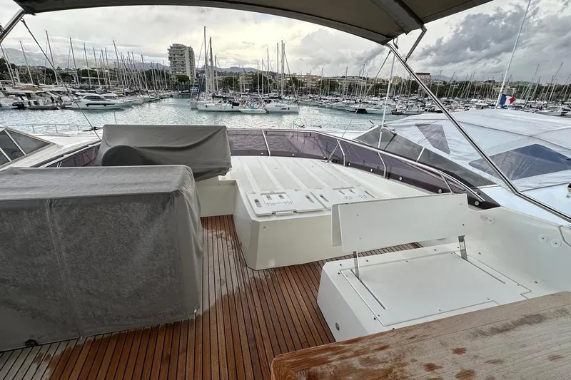  Yacht Photos Pics Flybridge of 2018 Prestige 520 yacht with marina view, featuring covered seating and wooden deck.