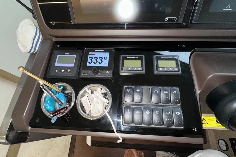  Yacht Photos Pics Control panel of a 2018 Prestige 520 yacht with navigation instruments and storage compartments.