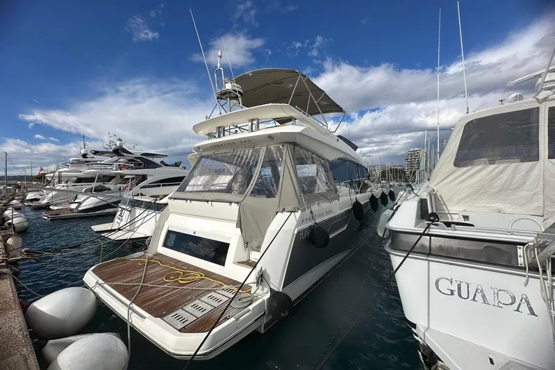  Yacht Photos Pics 2018 Prestige 520 yacht docked in a marina under a partly cloudy sky.