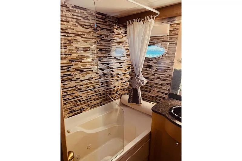 "robyn Faye" Yacht Photos Pics Luxurious bathroom in 1996 Forbes Cooper pilot house with mosaic tile wall and jacuzzi tub.
