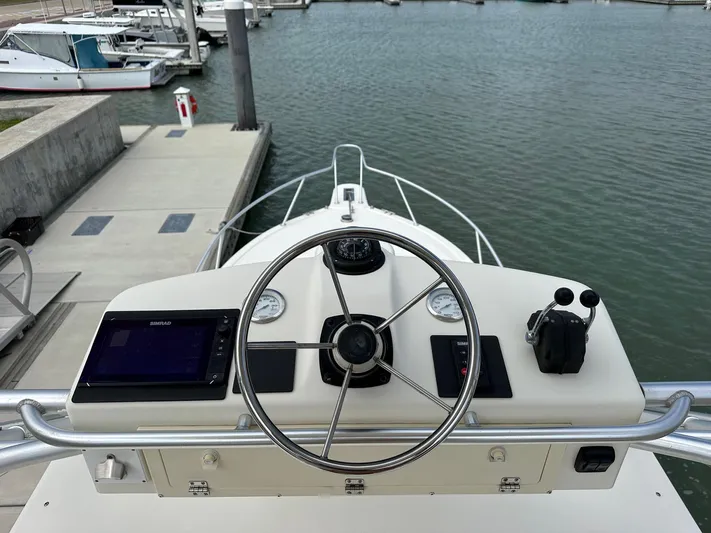  Yacht Photos Pics Helm of 2006 Albemarle 320 Express Fisherman at dock, featuring steering wheel and navigation equipment.