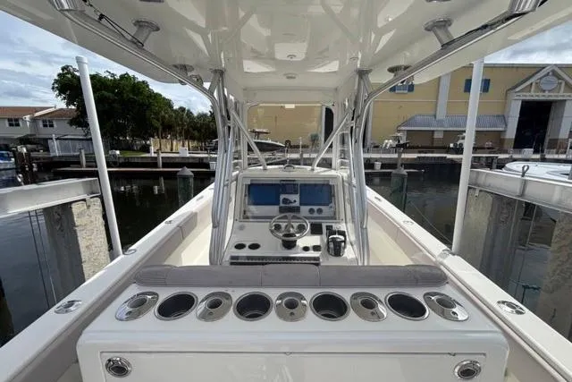  Yacht Photos Pics 2016 SeaVee 34 boat cockpit with steering wheel, control panel, and rod holders at marina.