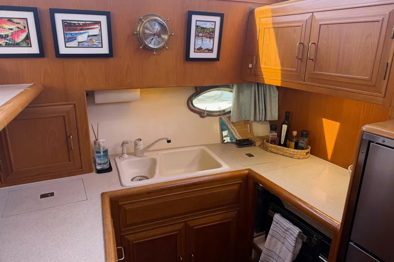  Yacht Photos Pics 1988 Ocean Alexander 42' yacht kitchen with wooden cabinets, sink, and nautical decor.