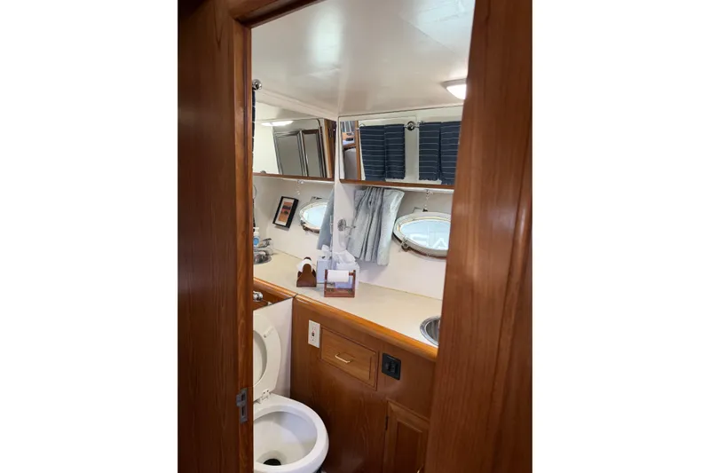  Yacht Photos Pics Bathroom interior of 1988 Ocean Alexander 42' yacht with wooden cabinetry and porthole windows.
