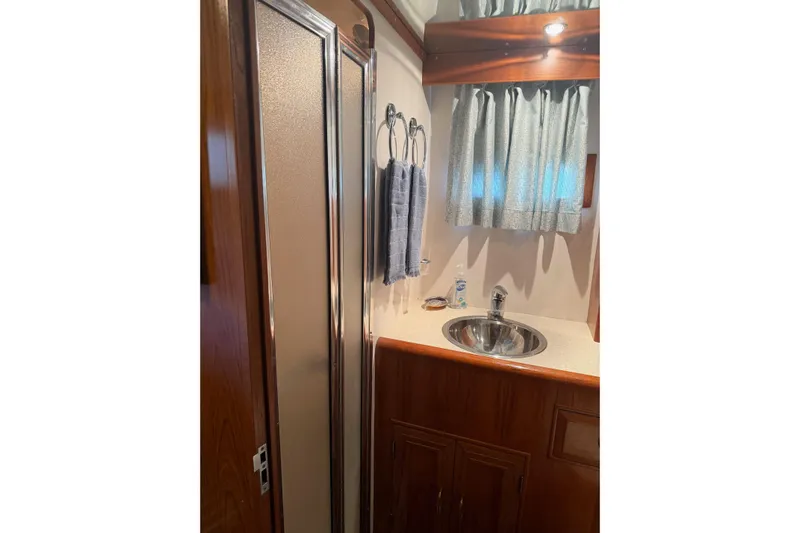  Yacht Photos Pics 1988 Ocean Alexander 42' yacht bathroom with sink, shower, and wooden cabinetry.