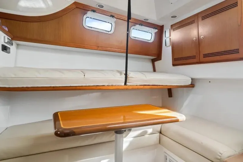 Gyro Stabilized Yacht Photos Pics Interior of 2005 Cabo 35 Express boat with wooden table and cushioned seating.
