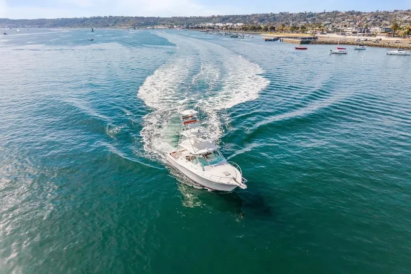 Gyro Stabilized Yacht Photos Pics 2005 Cabo 35 Express yacht cruising in open water near coastline.