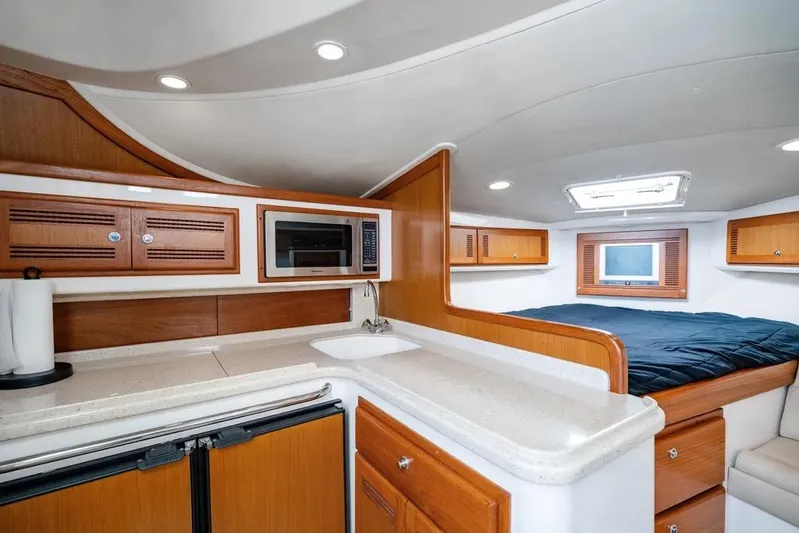 Gyro Stabilized Yacht Photos Pics 2005 Cabo 35 Express yacht interior with kitchenette, bed, and storage cabinets.