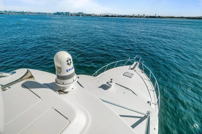 Gyro Stabilized Yacht Photos Pics 2005 Cabo 35 Express yacht on open water with city skyline in background.