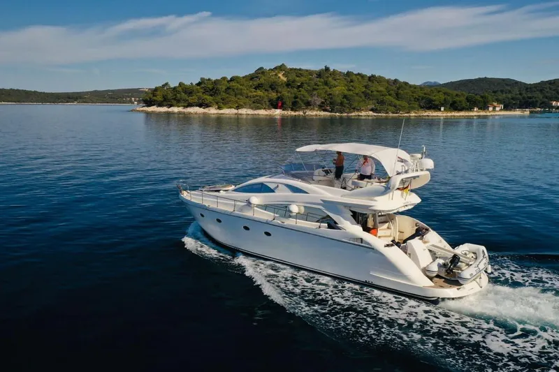  Yacht Photos Pics Luxury 2006 Aicon 56 yacht cruising near a scenic island.