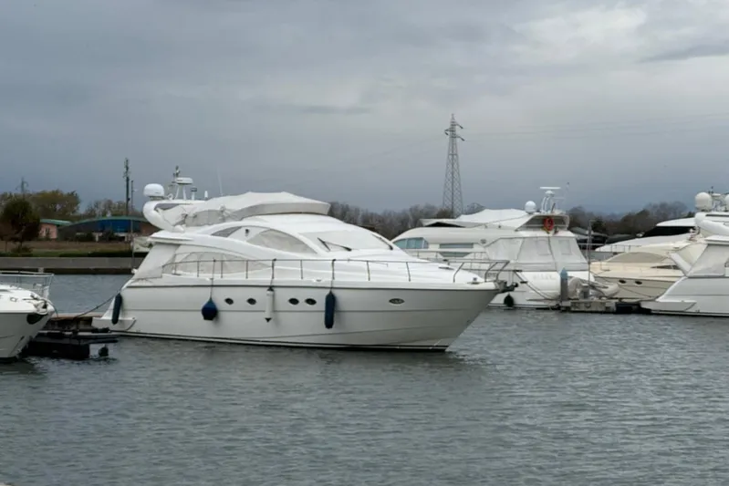  Yacht Photos Pics A 2006 Aicon 56 yacht docked in a marina under cloudy skies.