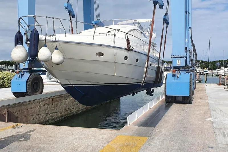  Yacht Photos Pics Aicon 56 yacht from 2006 being lifted by a blue crane at a marina.