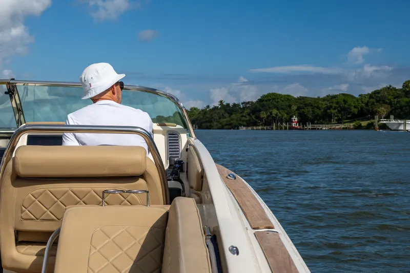  Yacht Photos Pics Man cruising on 2017 Chris-Craft Corsair 28 Heritage Edition boat, scenic waterway view.