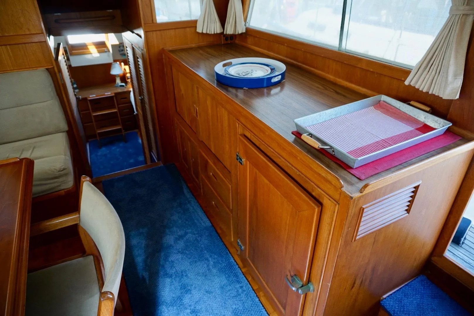 Interior of 1982 Grand Banks Classic yacht with wooden cabinetry and blue carpet.