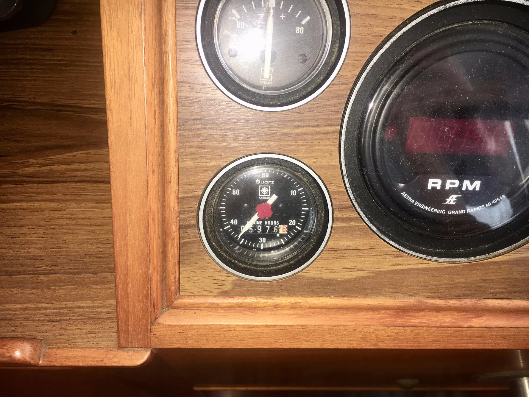 1982 Grand Banks Classic dashboard with RPM and hour gauges in wooden panel.