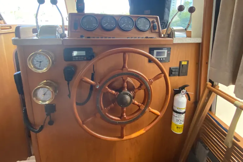 Eclipse Yacht Photos Pics 1999 Mainship 350 Trawler helm with wooden wheel, gauges, and fire extinguisher.