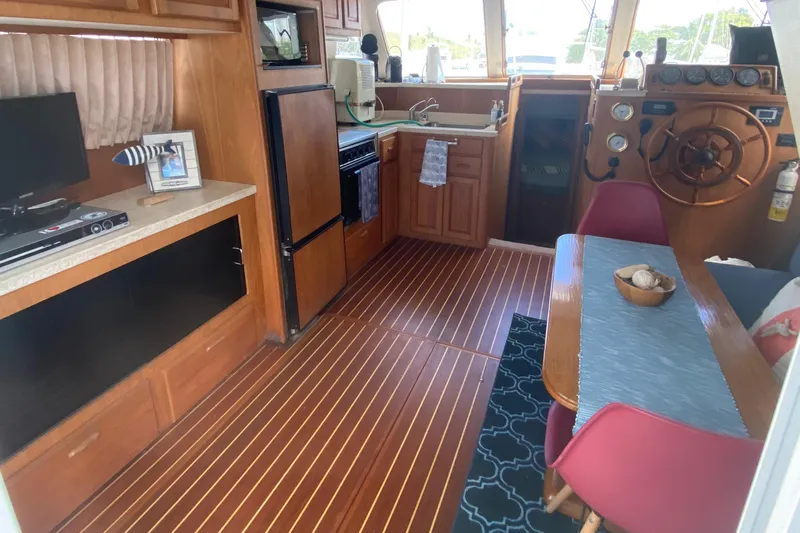 Eclipse Yacht Photos Pics 1999 Mainship 350 Trawler interior with kitchen, dining area, and helm station.