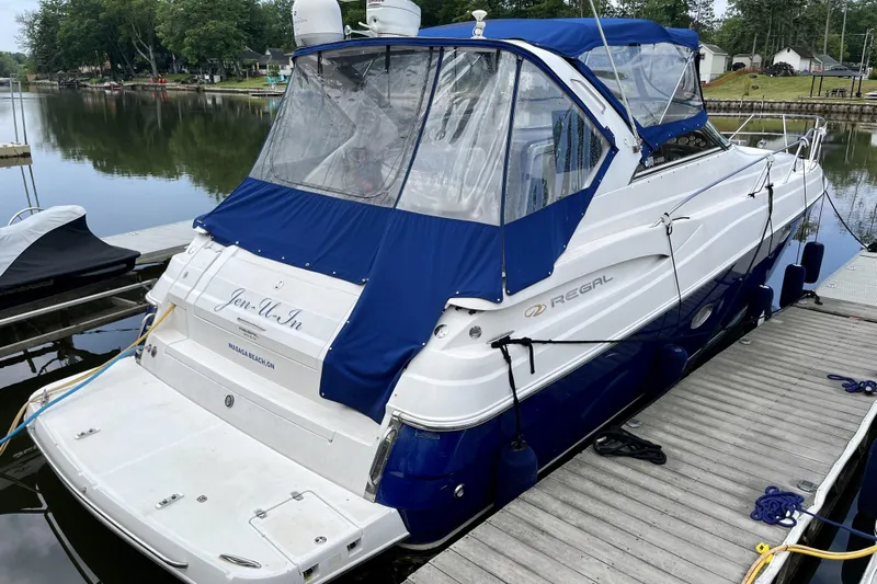  Yacht Photos Pics 2005 Regal Commodore 3560 boat docked at a marina with blue canopy.