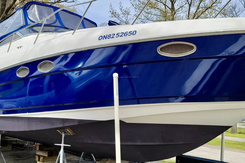  Yacht Photos Pics 2005 Regal Commodore 3560 boat with blue and white exterior, docked on land.