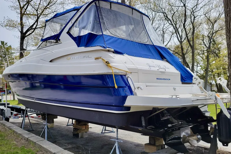  Yacht Photos Pics 2005 Regal Commodore 3560 boat on stands, blue and white exterior, covered, outdoor setting.