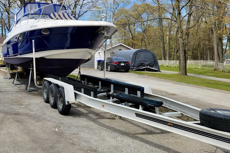  Yacht Photos Pics 2005 Regal Commodore 3560 yacht on trailer, parked outdoors near trees and a house.
