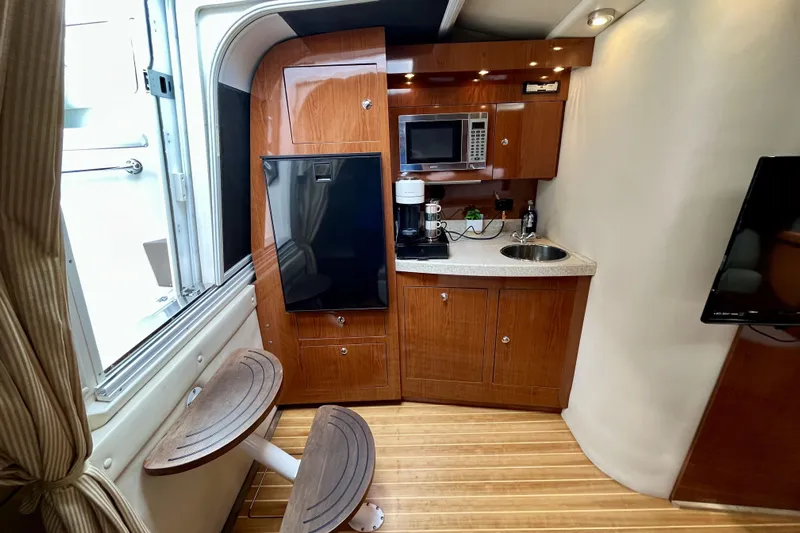  Yacht Photos Pics 2005 Regal Commodore 3560 yacht interior with kitchenette, featuring wood cabinetry and modern appliances.