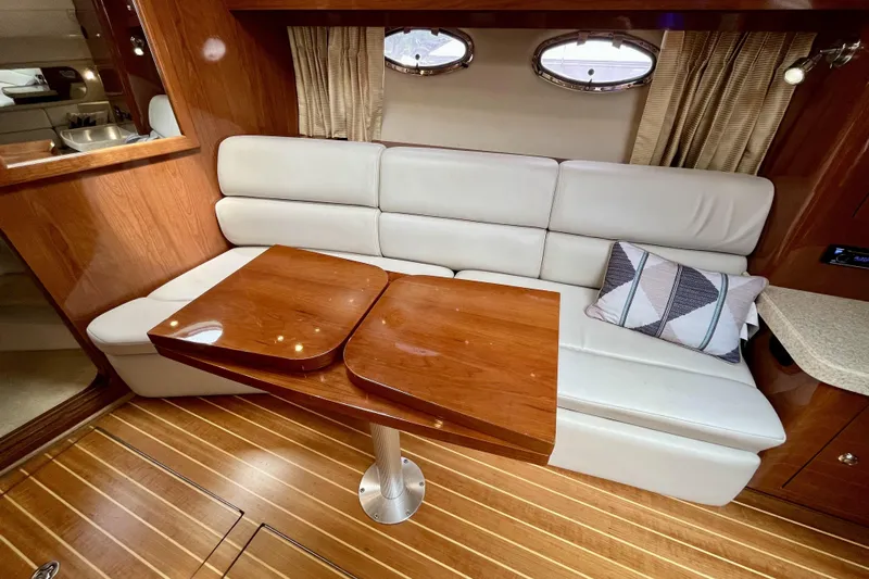  Yacht Photos Pics Luxurious interior of 2005 Regal Commodore 3560 yacht with plush seating and wooden table.