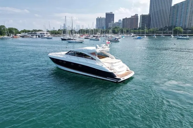  Yacht Photos Pics 2008 Princess V53 yacht on a serene harbor with city skyline backdrop.