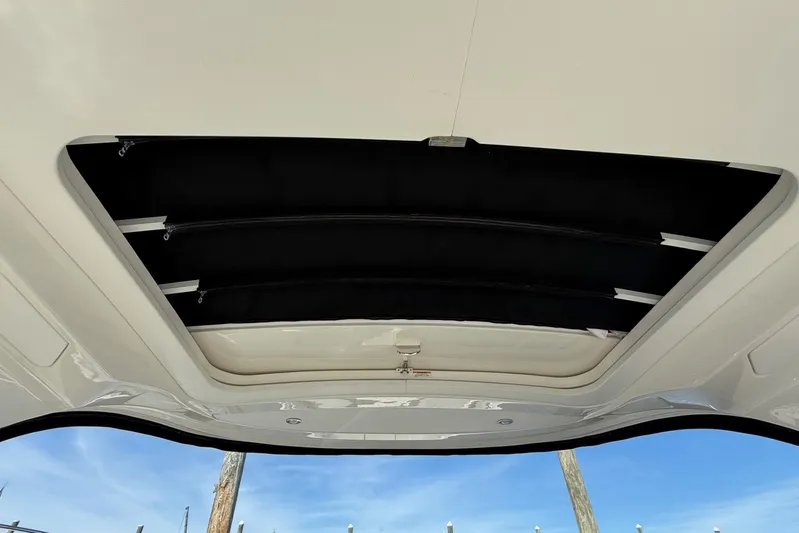  Yacht Photos Pics 2021 Sea Ray SLX 310 boat sunroof, open with clear blue sky view.