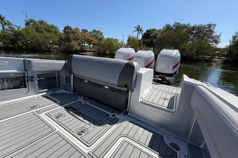  Yacht Photos Pics 2018 Nor-Tech 390 Sport Center Console boat with triple Mercury engines, docked by lush greenery.