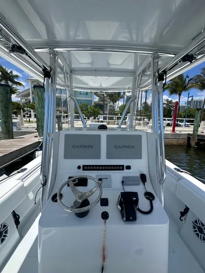  Yacht Photos Pics 2025 Contender 30 T boat console with Garmin displays, docked in a marina.
