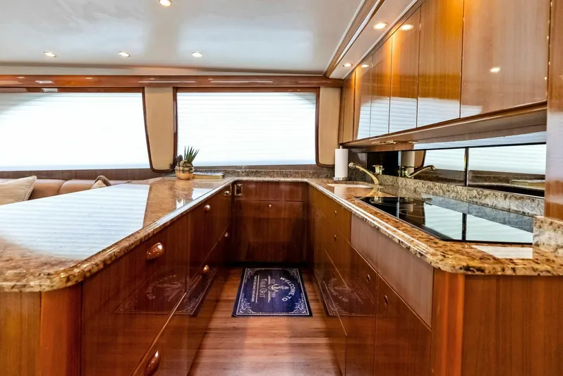 True Grit Yacht Photos Pics Luxurious kitchen interior of 2006 Viking 56 Convertible yacht with wood cabinetry and granite countertops.