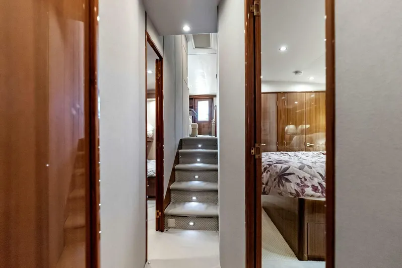 True Grit Yacht Photos Pics Interior hallway of 2006 Viking 56 Convertible yacht with carpeted stairs and wood paneling.