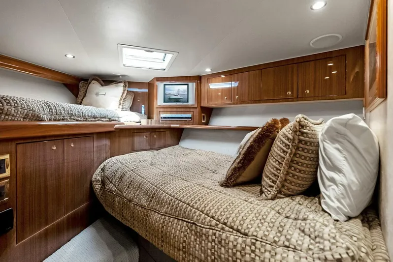 True Grit Yacht Photos Pics Luxurious cabin interior of 2006 Viking 56 Convertible yacht with cozy bedding and wood paneling.