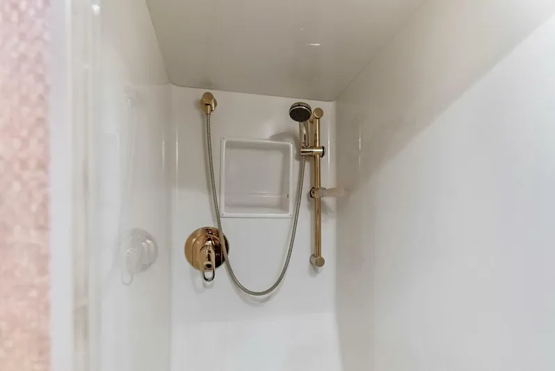 True Grit Yacht Photos Pics Shower area in 2006 Viking 56 Convertible yacht with gold fixtures.