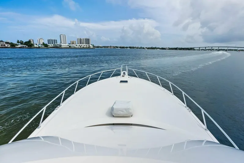 True Grit Yacht Photos Pics Viking 56 Convertible 2006 yacht cruising on open water with city skyline.