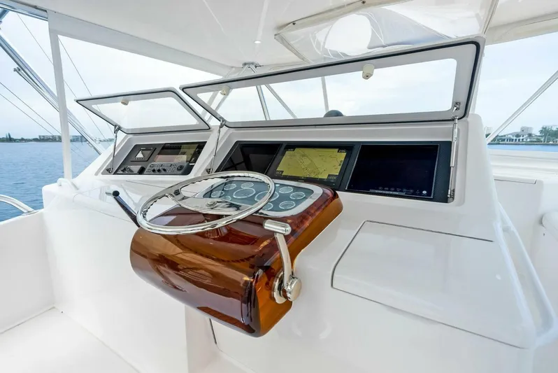 True Grit Yacht Photos Pics Viking 56 Convertible 2006 yacht helm with modern navigation equipment and wooden steering wheel.
