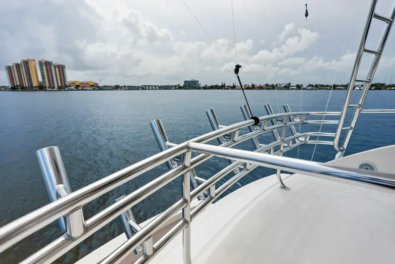 True Grit Yacht Photos Pics Viking 56 Convertible yacht, 2006 model, overlooking calm waters and distant cityscape.